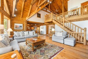 L’intérieur d’une cabane en rondins comprend un salon, un coin repas et un escalier.