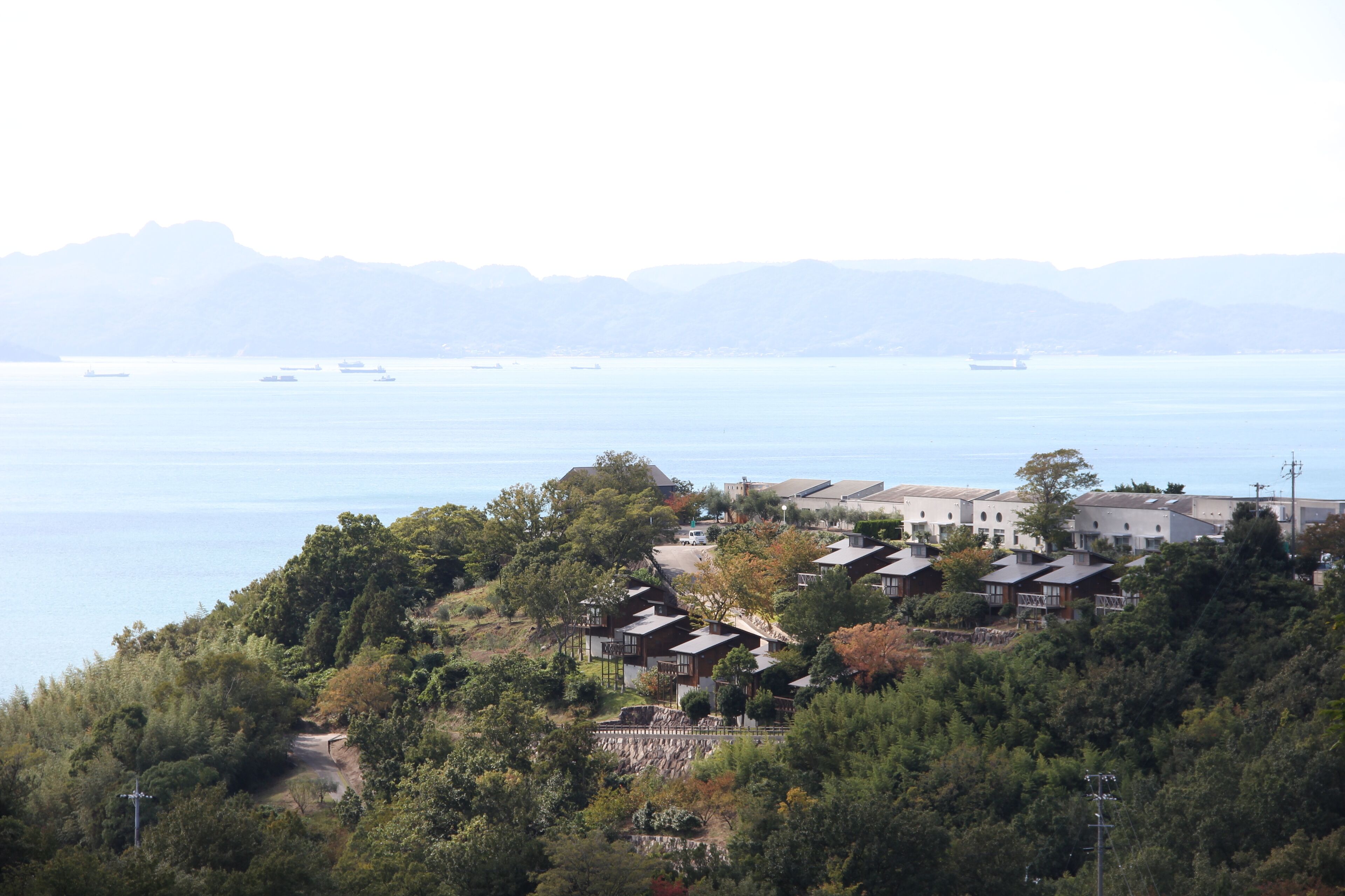 A coastal residential area with houses on a hillside overlooking the sea.