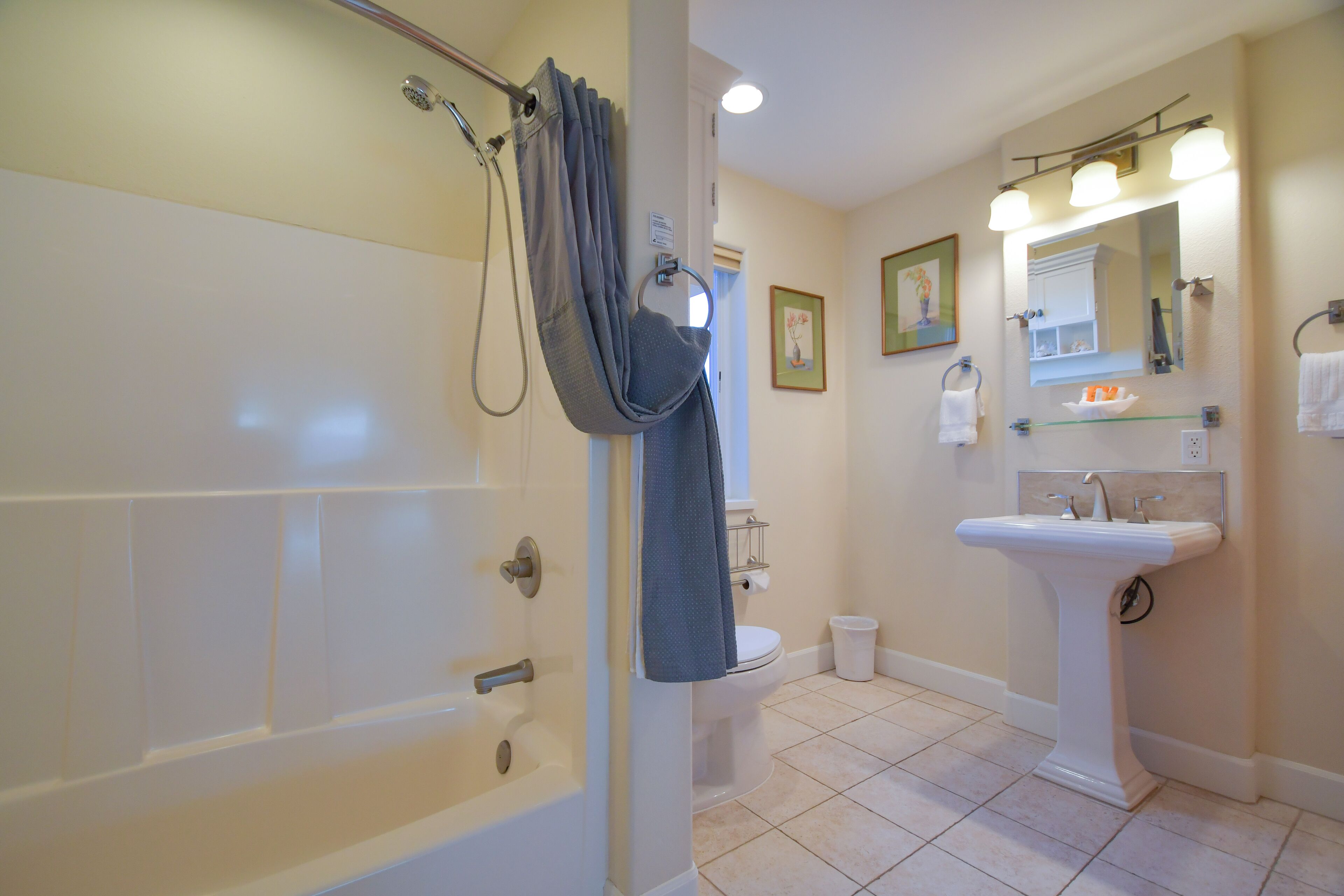 A bathroom with a bathtub, toilet, sink, and shower curtain.