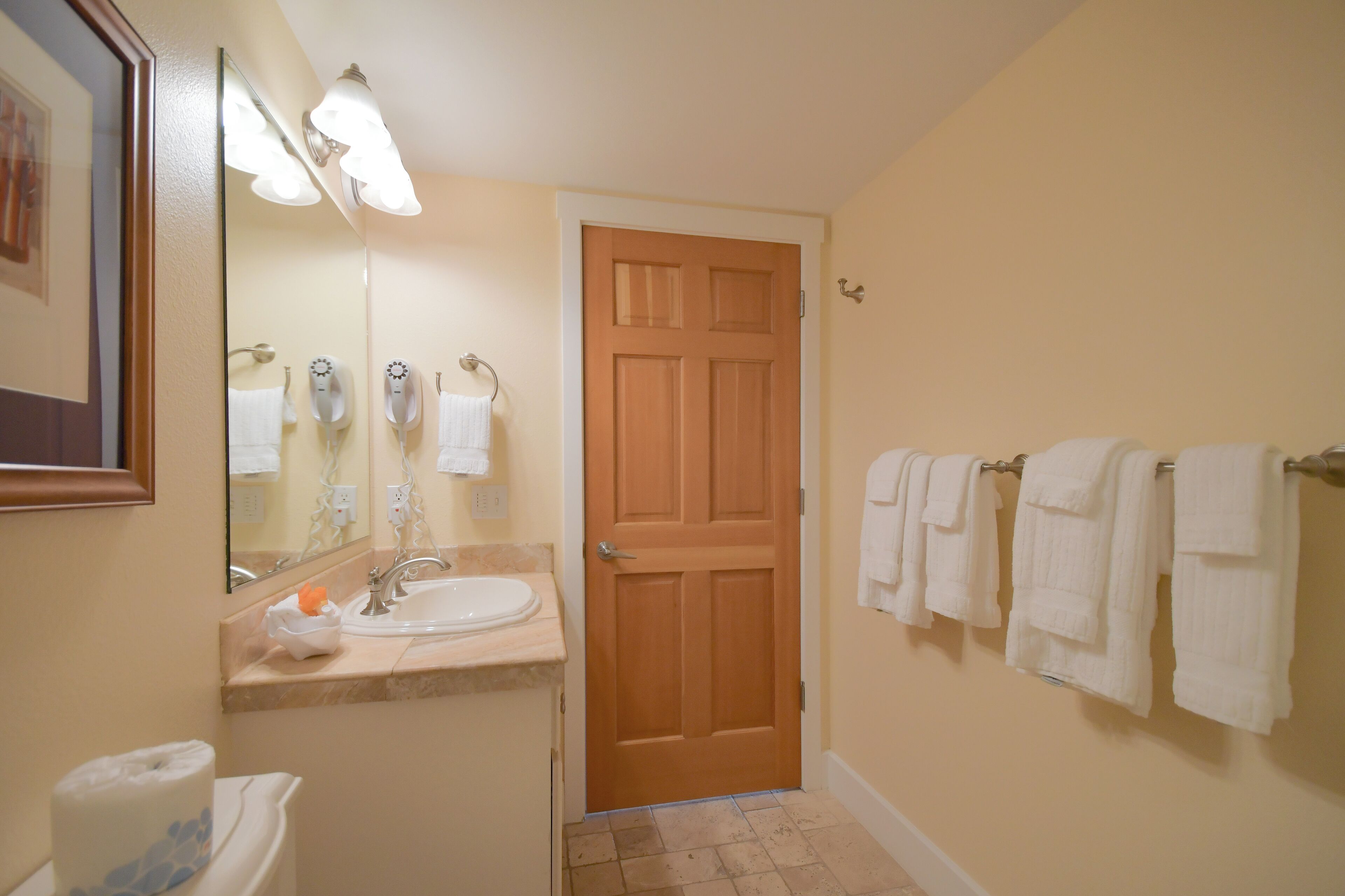 Un bagno con lavabo, specchio e porta in legno.