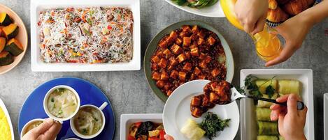 A variety of dishes on a table, including salads, soups, and a casserole dish.