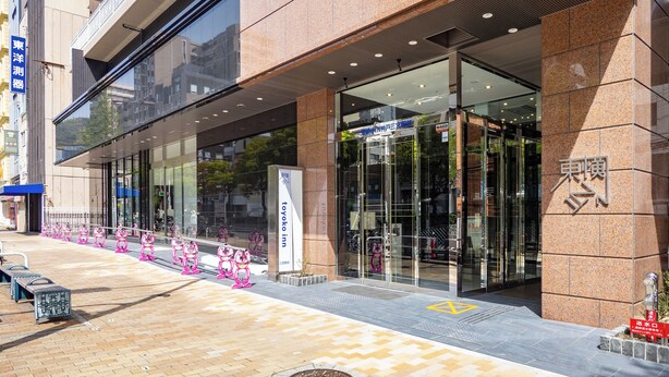 A modern building with a glass entrance, a blue sign, and a wheelchair-accessible ramp. - Toyoko Inn Kobe Sannomiya Ekimae (Kobe)