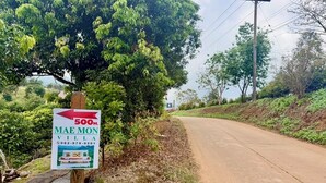 Schild für Mae Mon Villa, das eine Distanz von 500 Metern anzeigt.