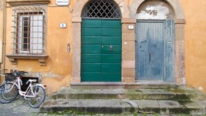Un edificio con dos puertas, una verde y otra azul, y una bicicleta estacionada al frente.