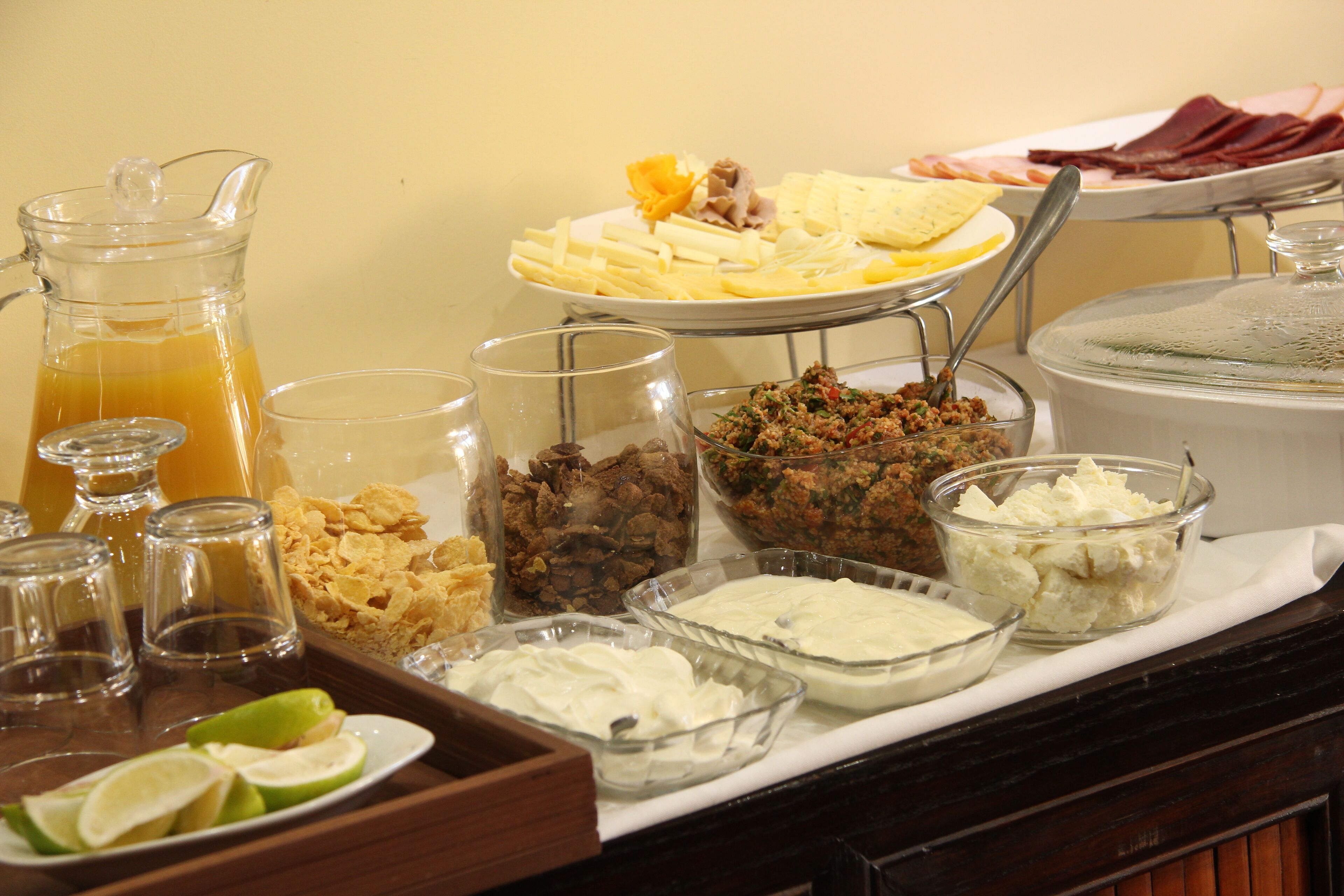 Buffet amb diverses seleccions de menjar, incloent fruita, formatges i carns.