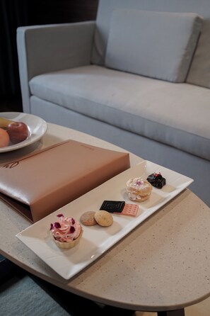A table with a dessert tray, a plate with fruits, and a brown box. - Tulip Inn Bhopal (Bhopal)