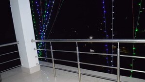 A metal railing with a tiled floor and a dark background. - Hotel Yumi Ragi (Papumpare)