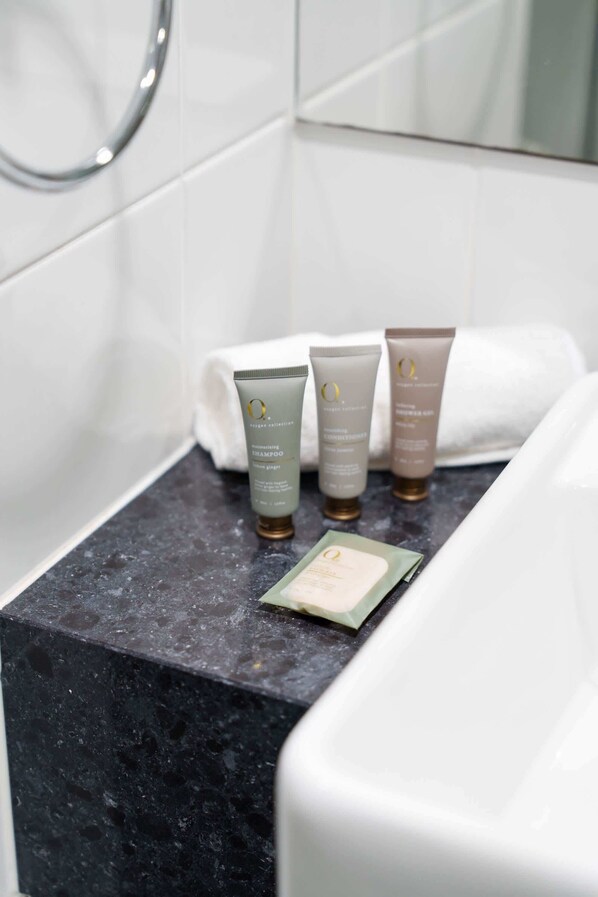 A bathroom with a black marble countertop, three toiletries, and a white towel.