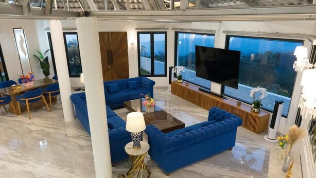 Una sala de estar moderna con un sofá azul, una mesa de centro y un televisor de pantalla plana.