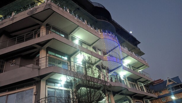 Un edificio a più piani con balconi, una scala a chiocciola e luci decorative.