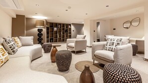 A modern living room with sofas, a coffee table, and decorative vases. - Le Madame by Sweett (Paris)