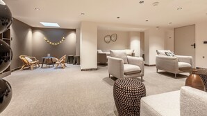 A modern living room with a sofa set, a coffee table, and a dining area with chairs. - Le Madame by Sweett (Paris)