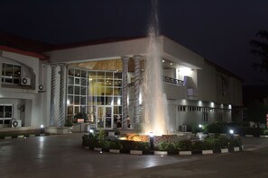 A building with large columns, a fountain, and a well-lit entrance. - Conference Hotel and Suites (Ijebu Ode)