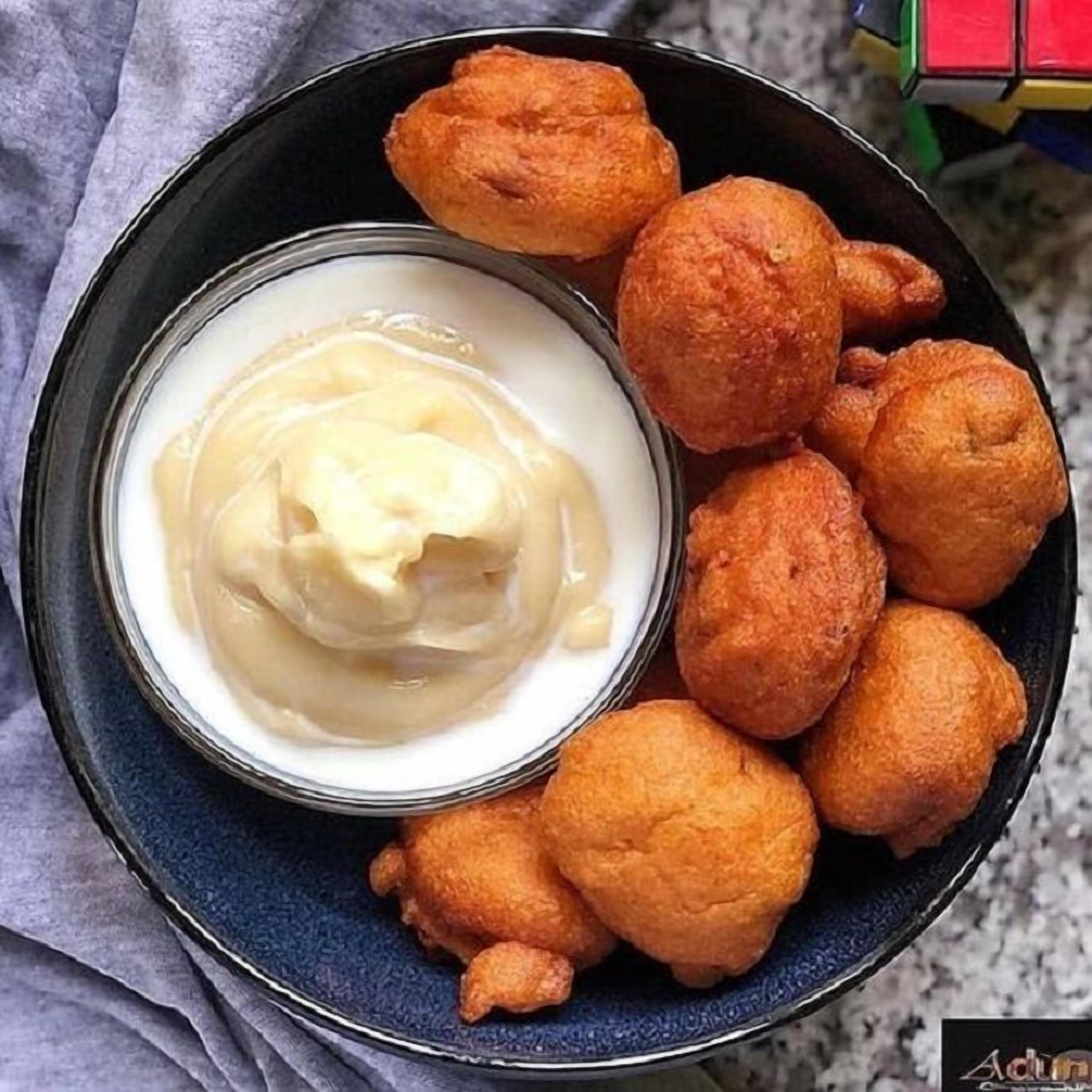 A bowl of food with a creamy substance and several round, golden-brown items on a plate.