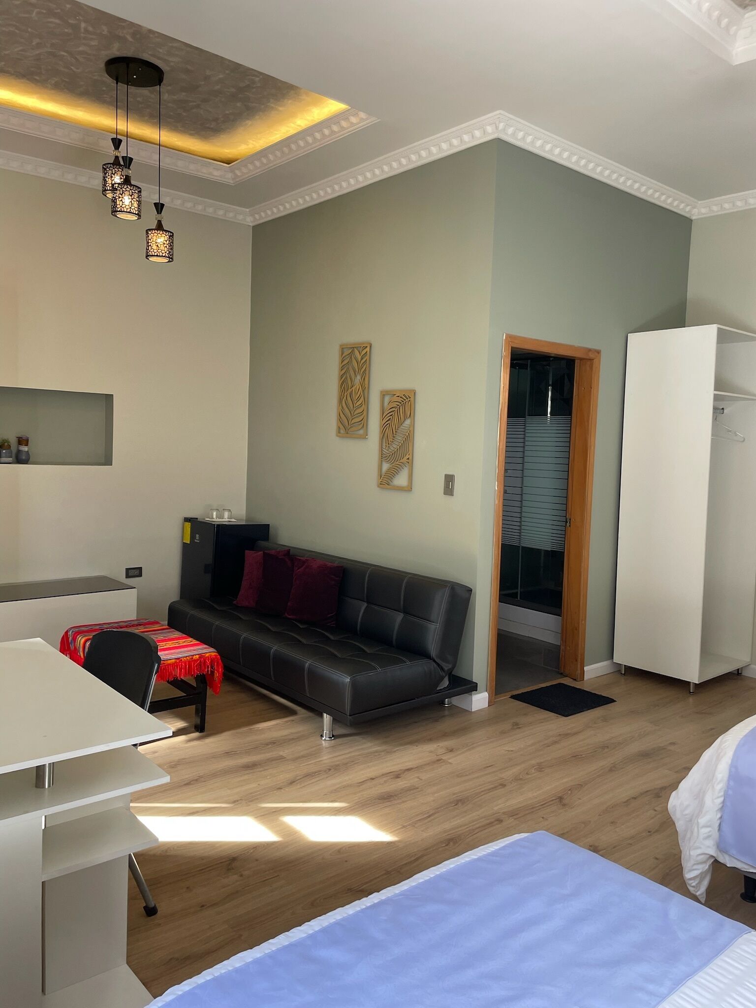 Una sala de estar moderna con sofá, mesa de comedor y kitchenette.