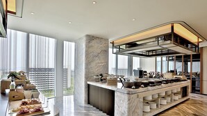 Una cucina moderna con piani in marmo, isola integrata e ampie finestre che offrono vista sulla città.