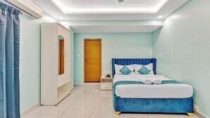 A bedroom with a bed, nightstand, wardrobe, and a door.