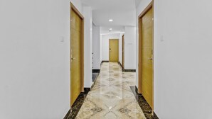 A hallway with a tiled floor and wooden doors.