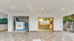 A hotel entrance with a reception desk, a manhole cover, and a tiled floor.