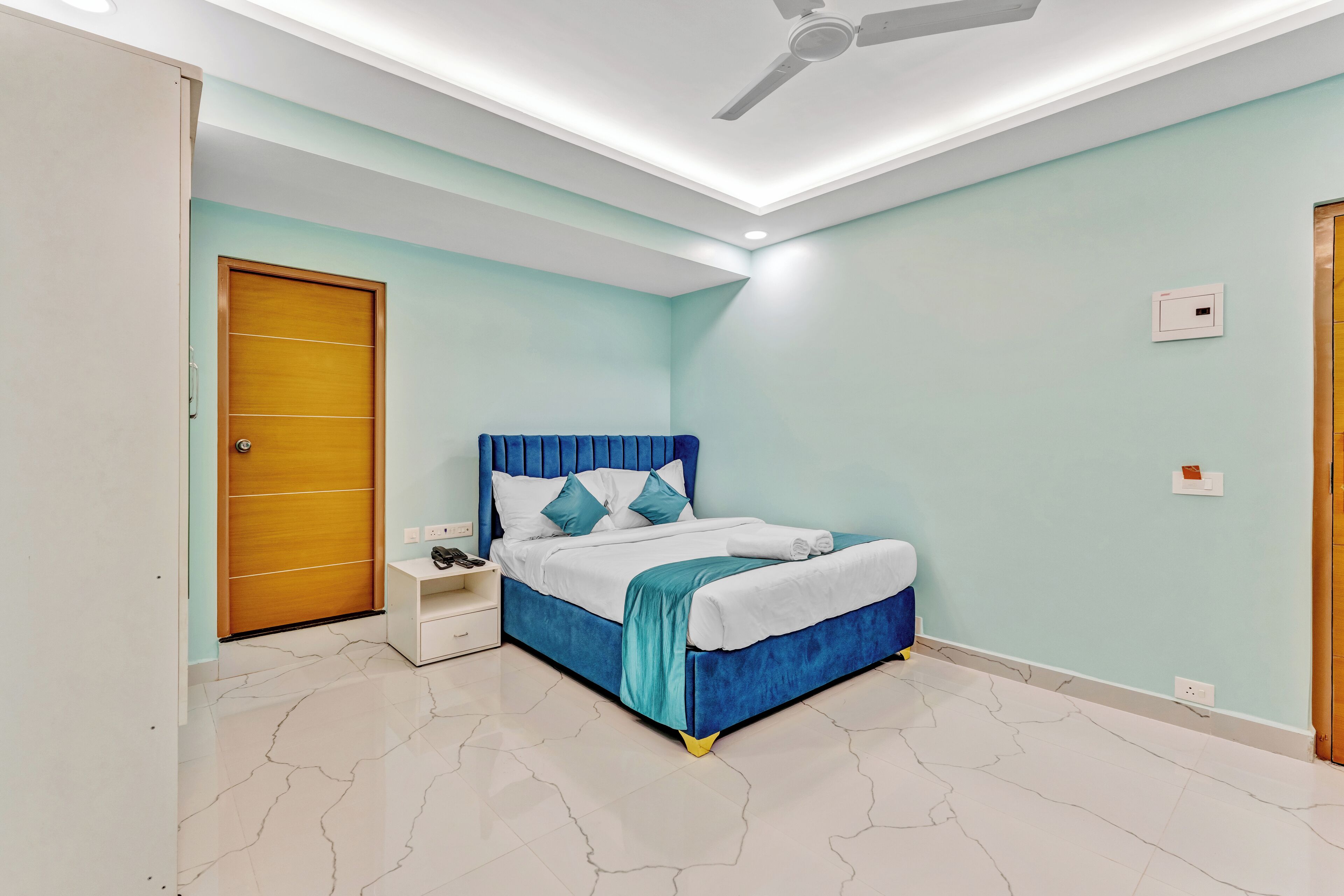 Ein Schlafzimmer mit Bett, Nachttisch und Deckenventilator.