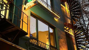 A building with a neon sign for "LOKKA BUTIK HOTEL" and a spiral staircase. - Lokka Hotel (Istanbul)