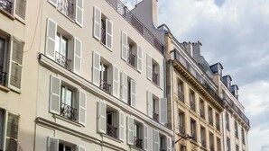 A multi-story building with white shutters and balconies. - Suites FL by Sweett (Paris)