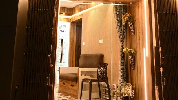 The exterior of Briu Inn with a well-lit entrance, a signboard, and a glimpse of the interior including a sofa and chairs. - Brij Inn (Varanasi)