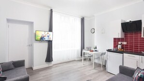 En moderne lejlighed med stue, spiseområde og køkken.