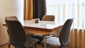 Uma área de refeições com uma mesa retangular e quatro cadeiras.