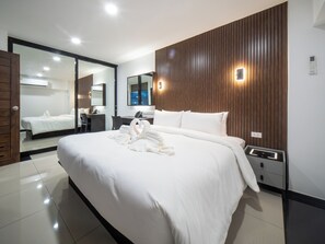 Une chambre d’hôtel moderne avec un grand lit, un bureau et un miroir.