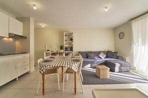 Una cucina moderna con un tavolo da pranzo, sedie e un divano nella zona living.