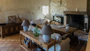 Un salon de style rustique avec une cheminée, des meubles en bois et un lustre.