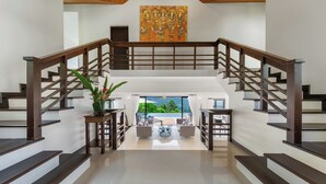 Un grand escalier offrant une vue sur un balcon et un espace extérieur.
