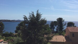 Blick auf die Küste, strahlend blauer Himmel, ein Gewässer und ein Gebäude mit einem Ziegeldach.