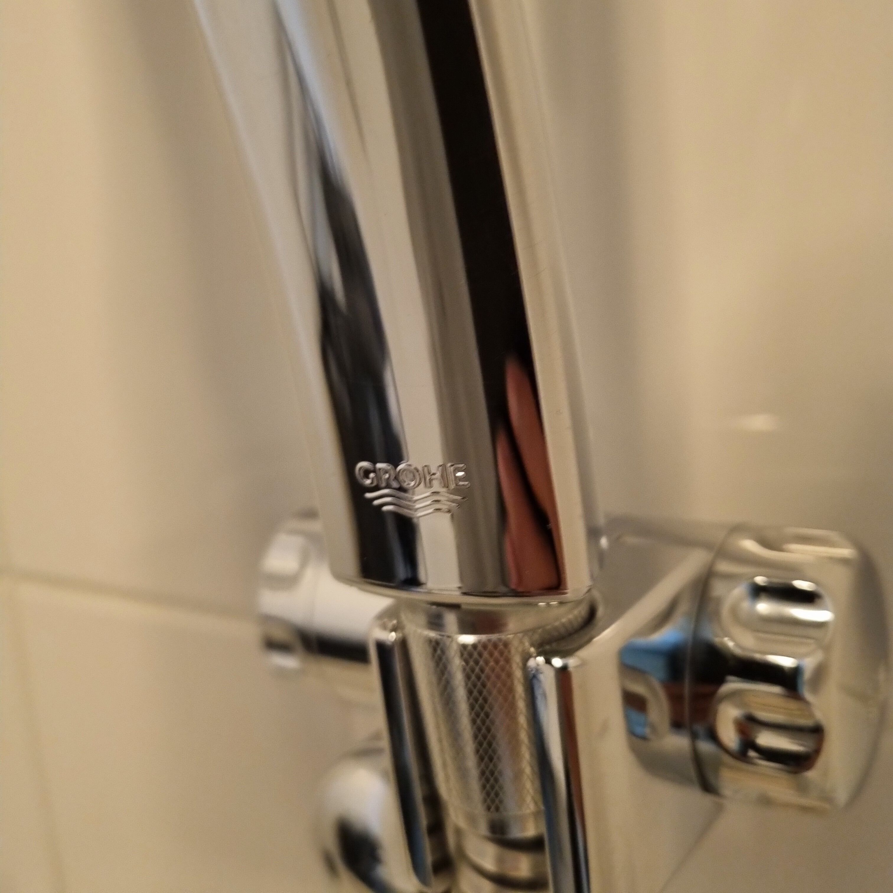 A chrome faucet with the brand name GROHE visible on the handle.