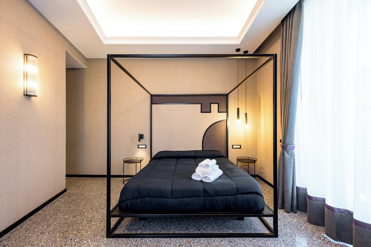 Ein modernes Hotelzimmer mit Himmelbett, Oberlicht und Blick auf die Stadt.