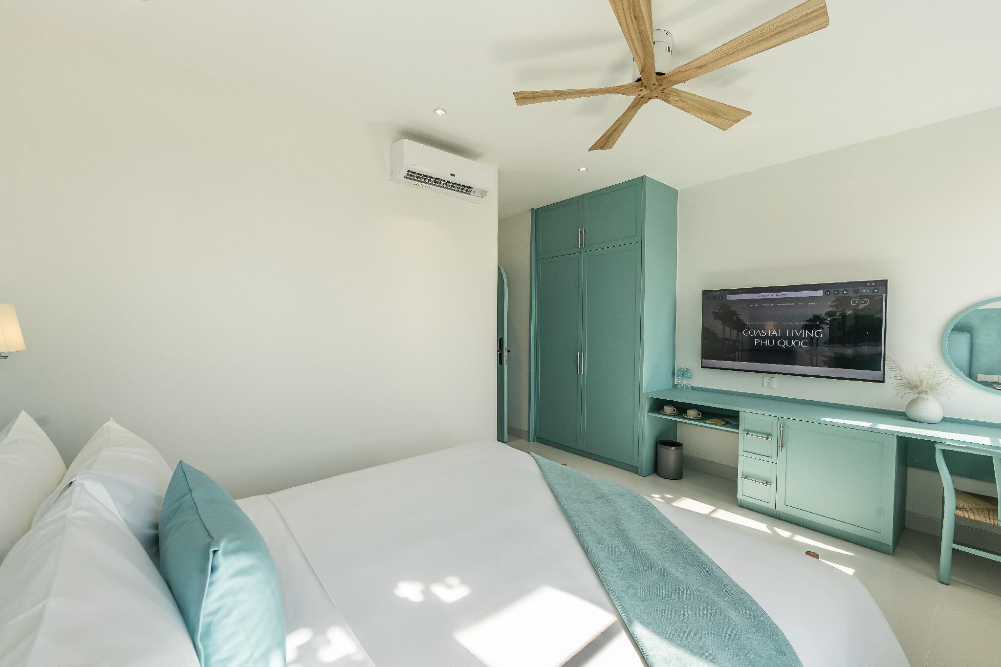 Ein Schlafzimmer mit Bett, Fernseher, Deckenventilator und Kleiderschrank.