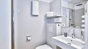 A modern bathroom with a white sink, a toilet, and a shower.