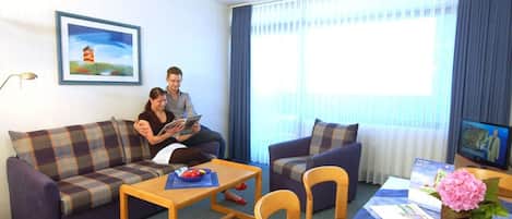 Una sala de estar con un sofá, una mesa de centro y un televisor.