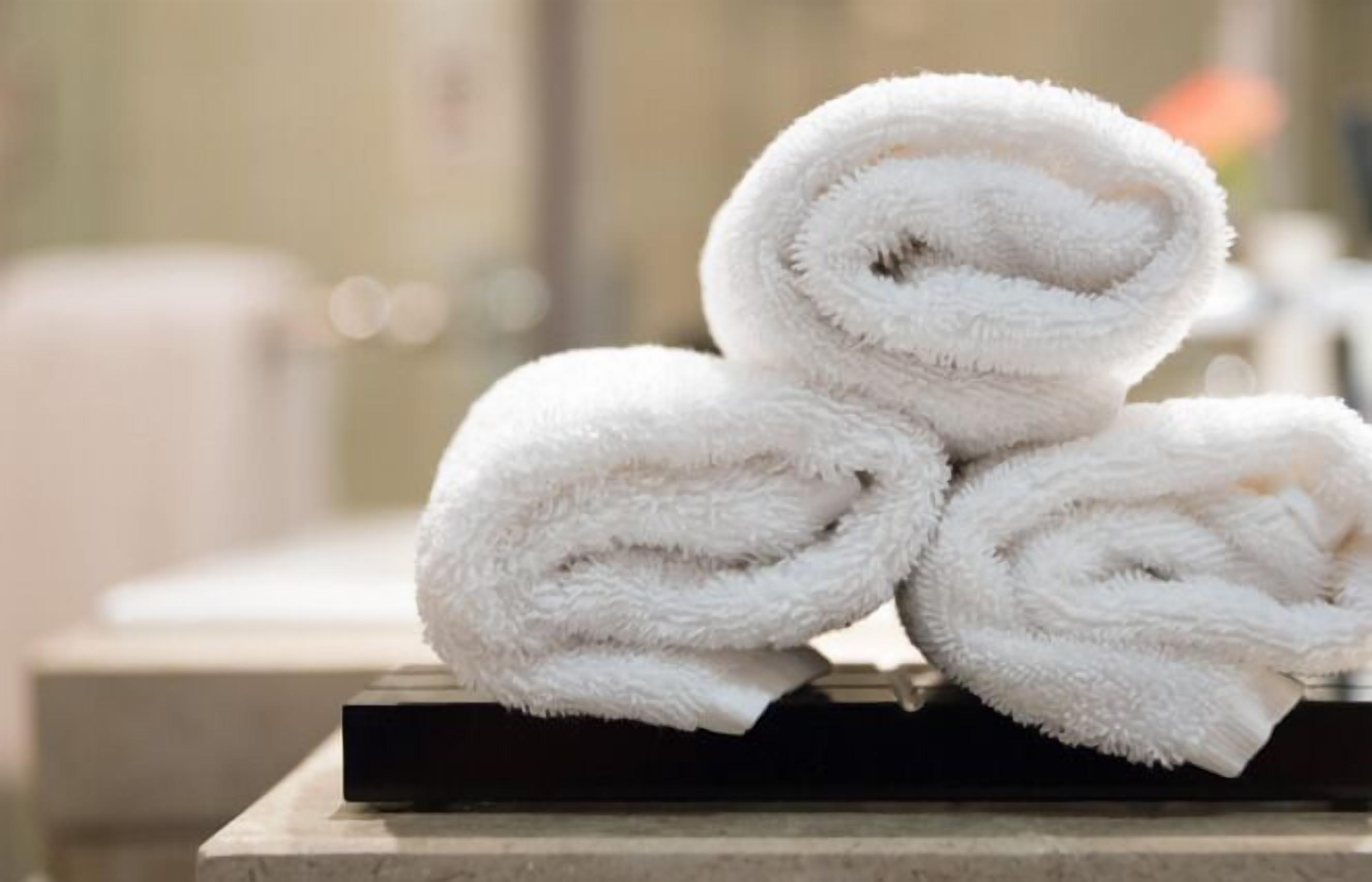 A stack of white towels on a black tray.