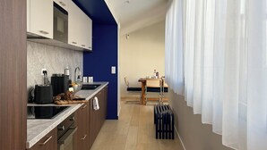 Eine moderne Küche mit Holzschränken, einem Einbauofen und einem Essbereich mit Tisch und Stühlen.