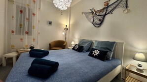 A bedroom with a large bed, a chair, a desk, and a wall-mounted hammock. - Casa Angela by Ca-sa Check (Chioggia)