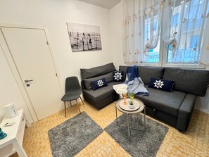 A modern living room with a grey sofa, a small round table, and a grey rug. - Casa Angela by Ca-sa Check (Chioggia)