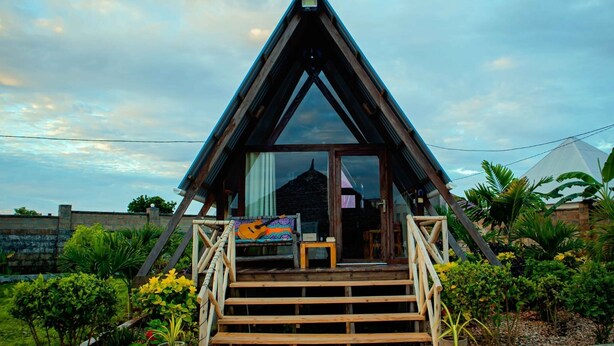 A triangular building with a wooden staircase leading to a glass door. - Cozy A-frame Retreat in Zanzibar Nungwi Leo Glamping (Nungwi)