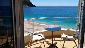 A balcony with two chairs and a small table, overlooking a beach and the sea. - Magic Ionian Apartments & Rooms (Himarë)