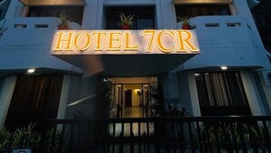 A multi-story hotel with a prominent illuminated sign reading "HOTEL 7CR". - Hotel 7 Cr (Vadodara)