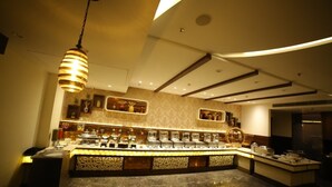 A modern kitchen with a central island, overhead lighting, and built-in appliances. - Hotel Imperia Suites (Jalandhar)