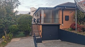 Ein modernes Haus mit überdachter Veranda, Garage und Satellitenschüssel.