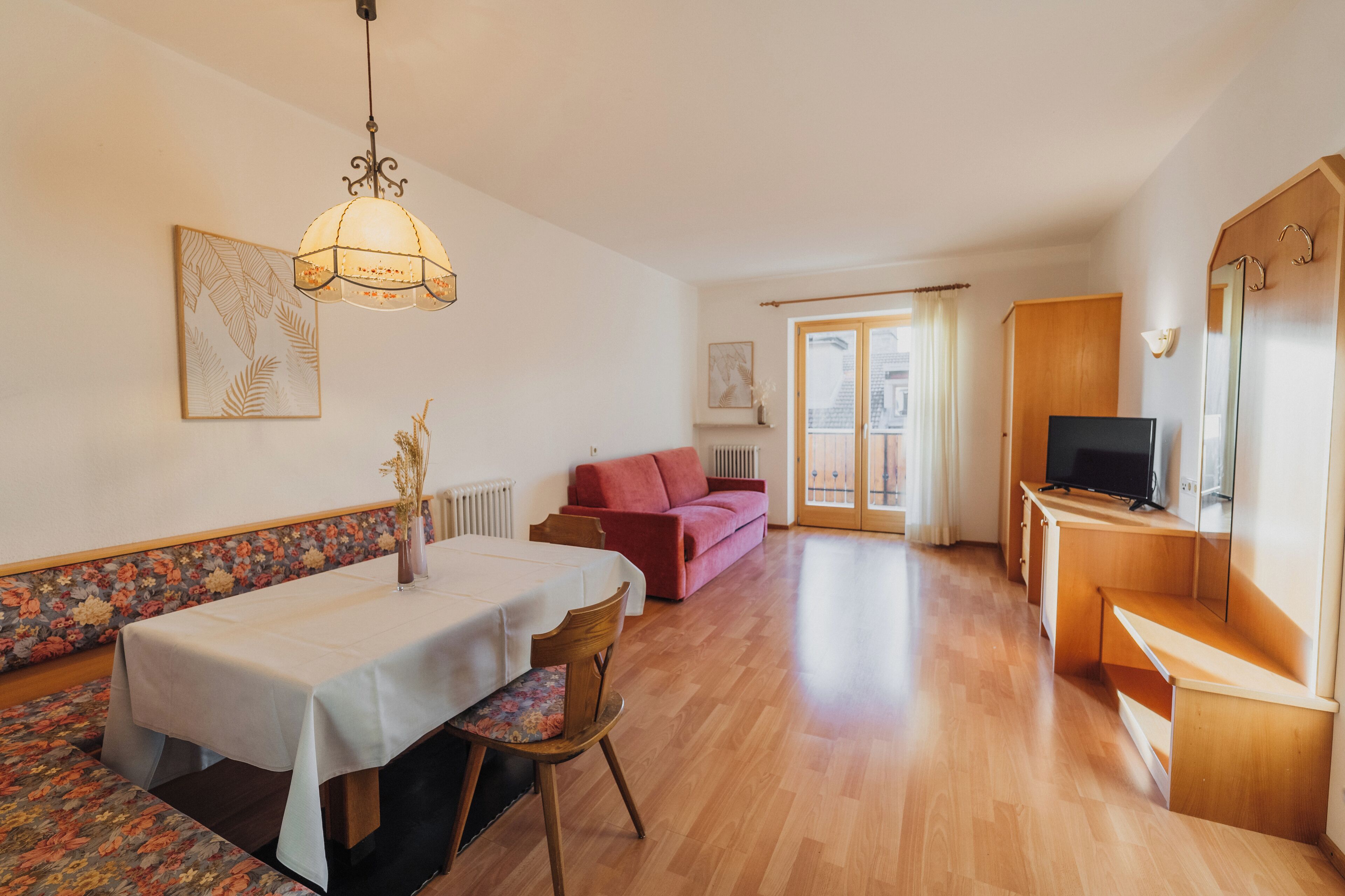 Ein geräumiger Wohnbereich mit Esstisch, Sofa und Fernseher-Schrank.