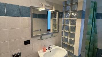 Apartamento | Banheiro | Chuveiro, secador de cabelo, toalhas de banho, papel higiênico